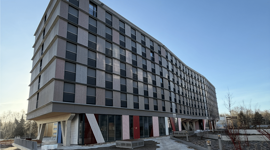 Moderner Gebäudekomplex mit Holzfassade und großen Fenstern, Baustoffe für Systembau.
